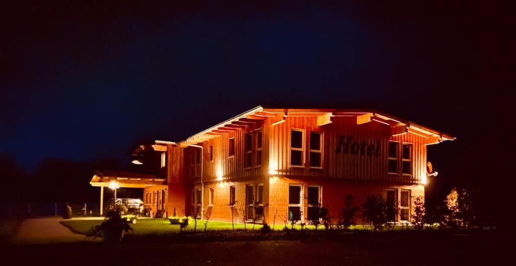 Una casa se ilumina por la noche en Hotel Rappenhof, en Breuna