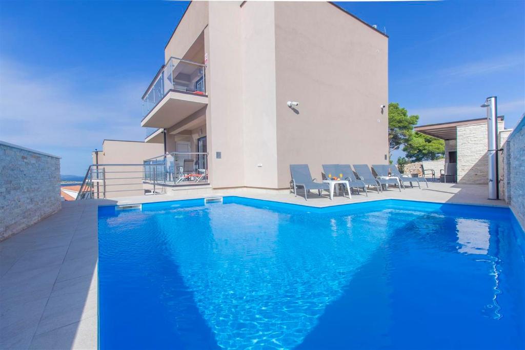 uma piscina em frente a uma casa em Villa top of Murter, two bedroom apartment 2 em Murter