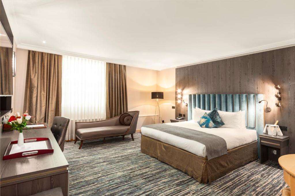ロンドンにあるコートハウス ホテル ロンドンのベッドとデスクが備わるホテルルームです。