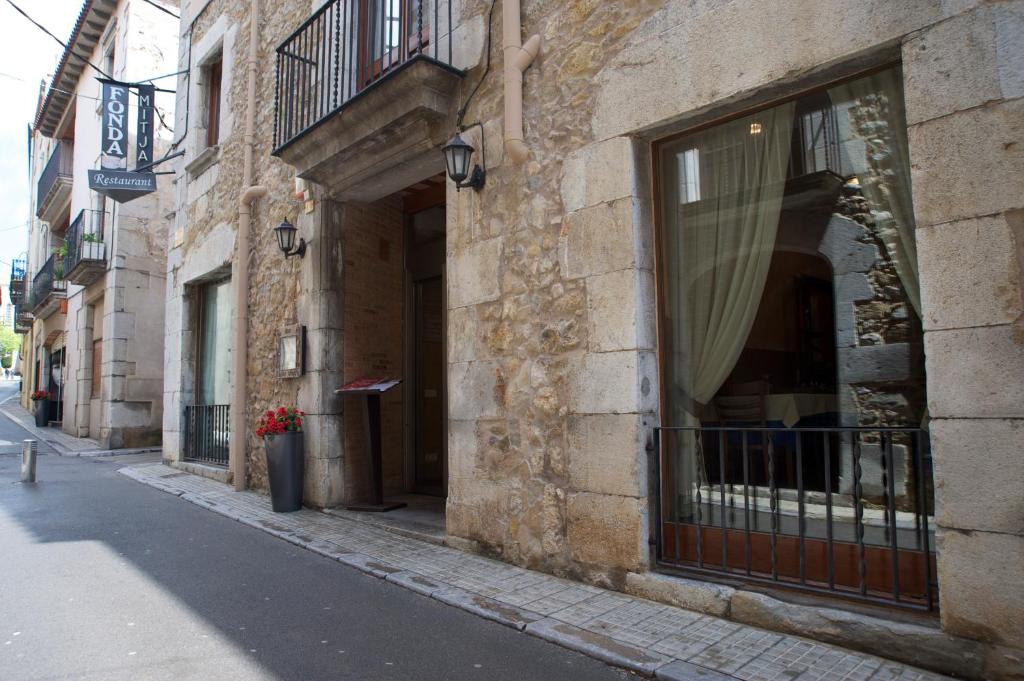 um edifício com uma janela do lado de uma rua em Fonda Mitjà em Torroella de Montgrí