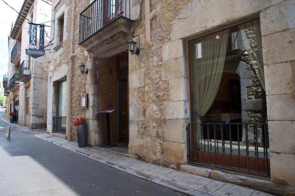 a building with a window on the side of a street at Fonda Mitjà in Torroella de Montgrí