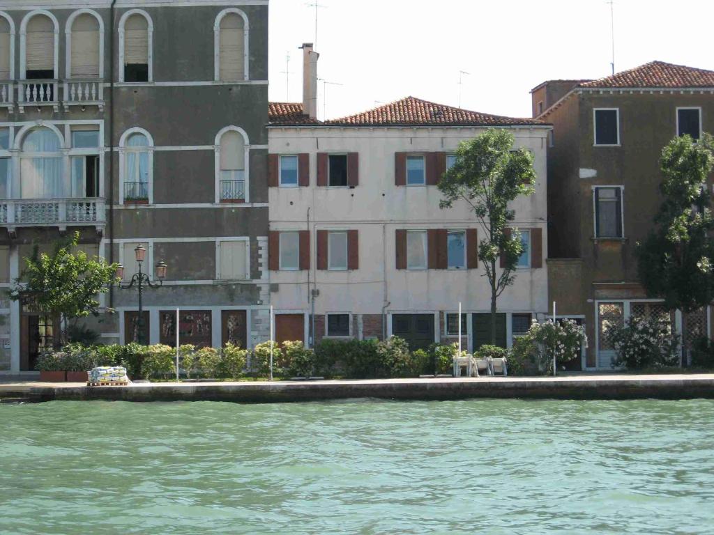 un groupe de bâtiments à côté d'une masse d'eau dans l'établissement Cà Isabella, à Venise