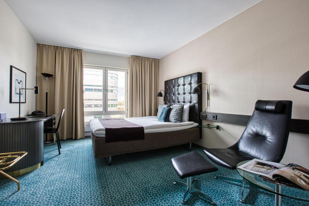 una camera d'albergo con letto, scrivania e sedia di Memory Hotel a Stoccolma