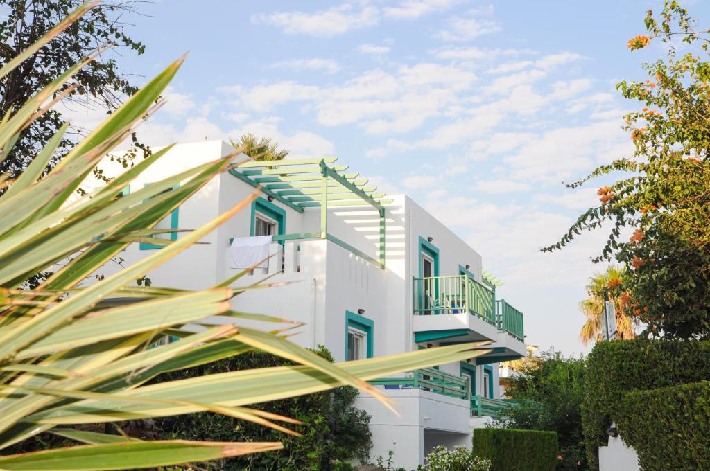 a white building with green and yellow accents at Mastichari Bay Hotel in Mastihari