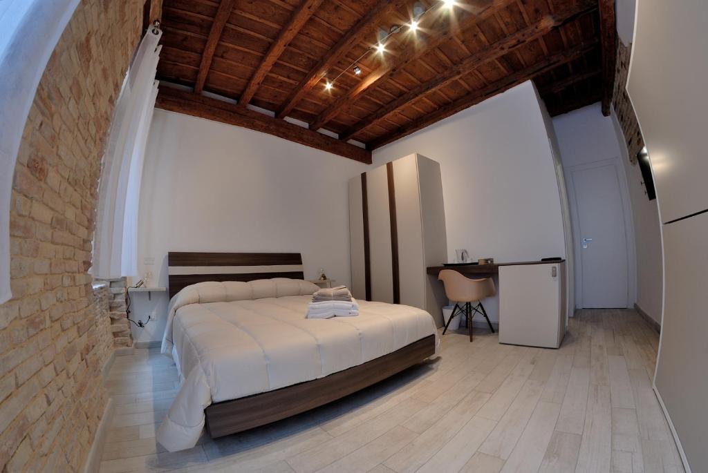 a bedroom with a large bed and a table at B&B DEL CORSO in Loreto