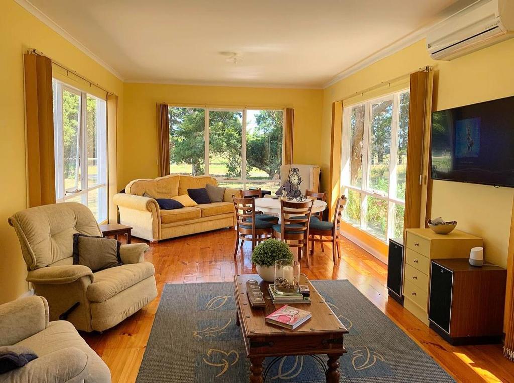 un salon avec un canapé et une table dans l'établissement Bellaghy Cottage, à Wimbledon Heights