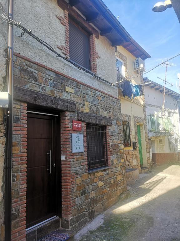 un edificio de ladrillo con una puerta en una calle en Apartamento Rural La Brígida, Rubiaco, LAS HURDES nº TR-CC-295, en El Rubiaco