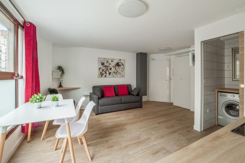 een woonkamer met een witte tafel en een bank bij Bright and cosy flat at the heart of Paris in a trendy district - Welkeys in Parijs