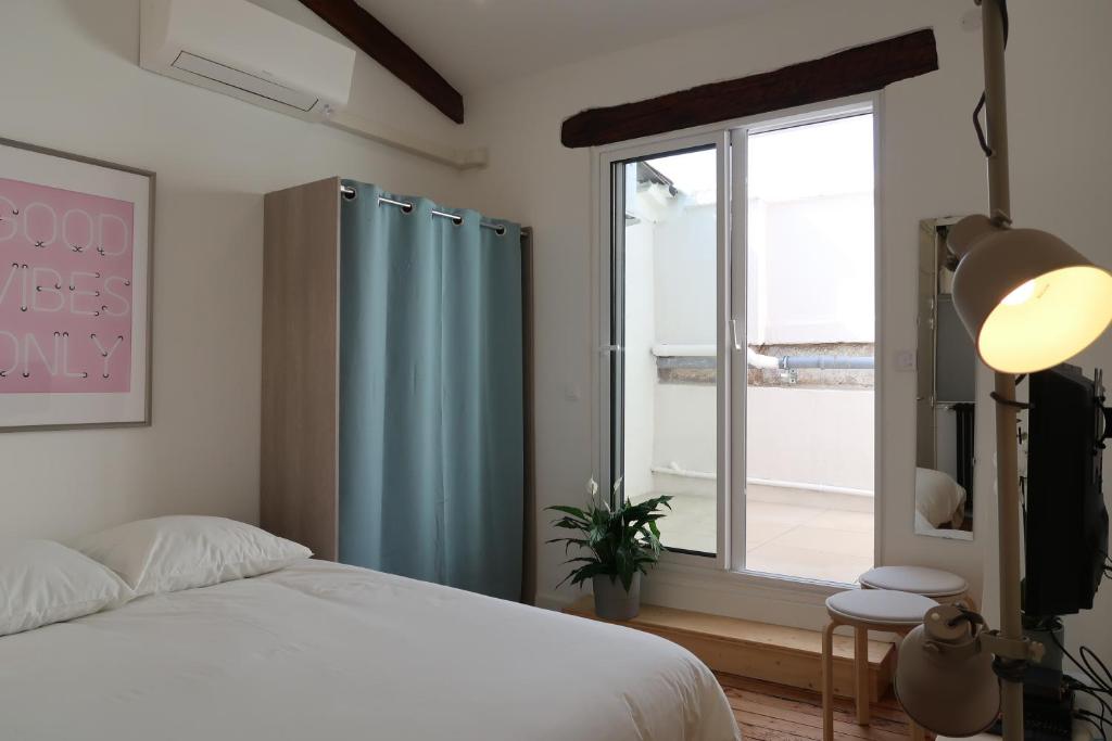 une chambre avec un lit et une grande fenêtre dans l'établissement La Terrasse de Wilson, à Toulouse