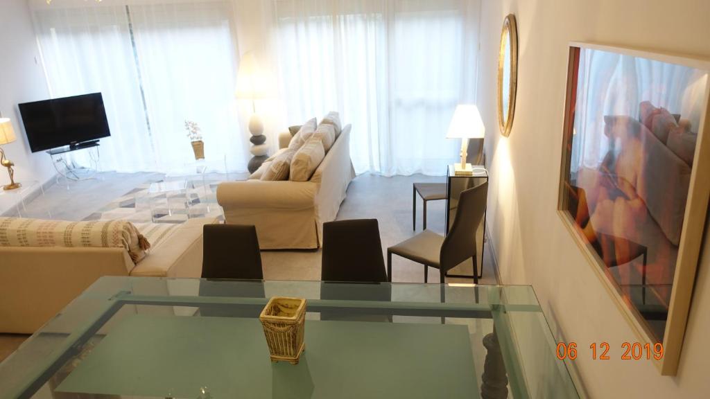 uma sala de estar com uma mesa de vidro e uma sala de estar em AU COEUR DES LICES *** CENTRE HISTORIQUE AVIGNON em Avignon