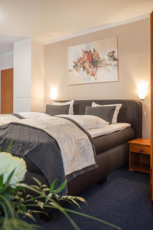 Un dormitorio con una cama y un cuadro en la pared. en Hotel Nordig free parking, en Flensburg