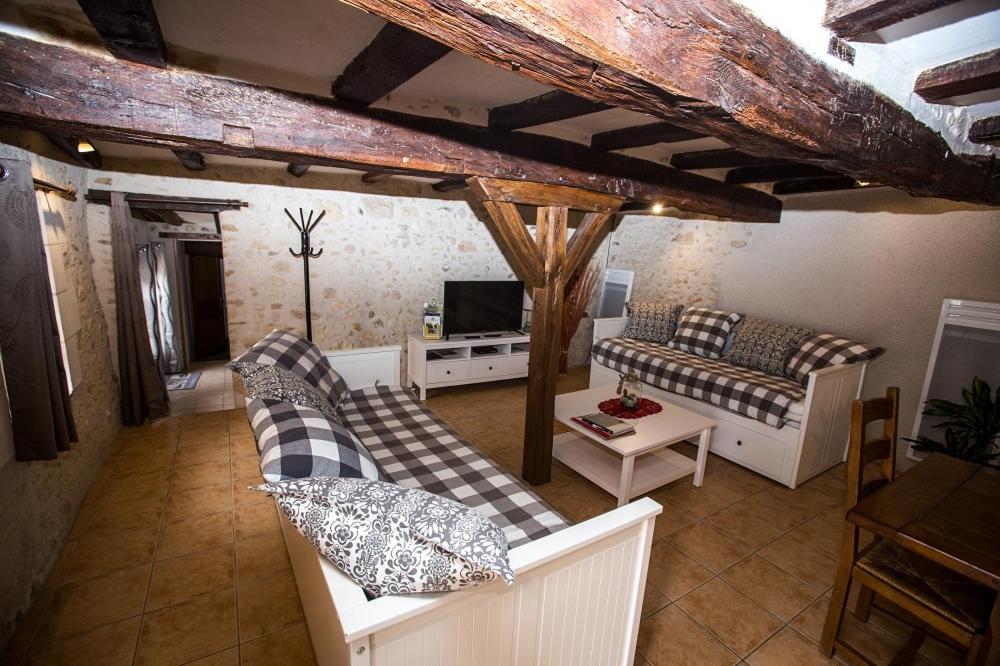 un salon avec deux canapés et une télévision dans l'établissement Charme et Spa dans un domaine d'élevage, à Sennevières