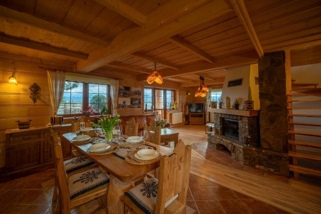 a dining room with a table and a fireplace at Widokowa Górka in Czerwienne