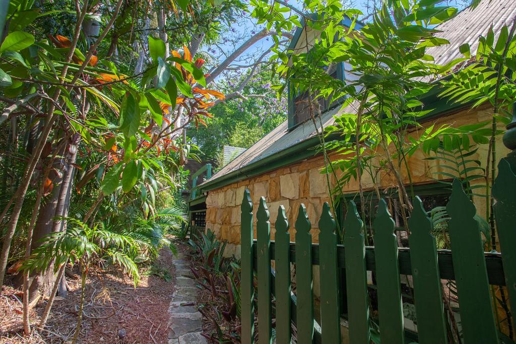 a green fence next to a house with trees at Woolwich Studio Bliss, Private Oasis by the Water in Sydney