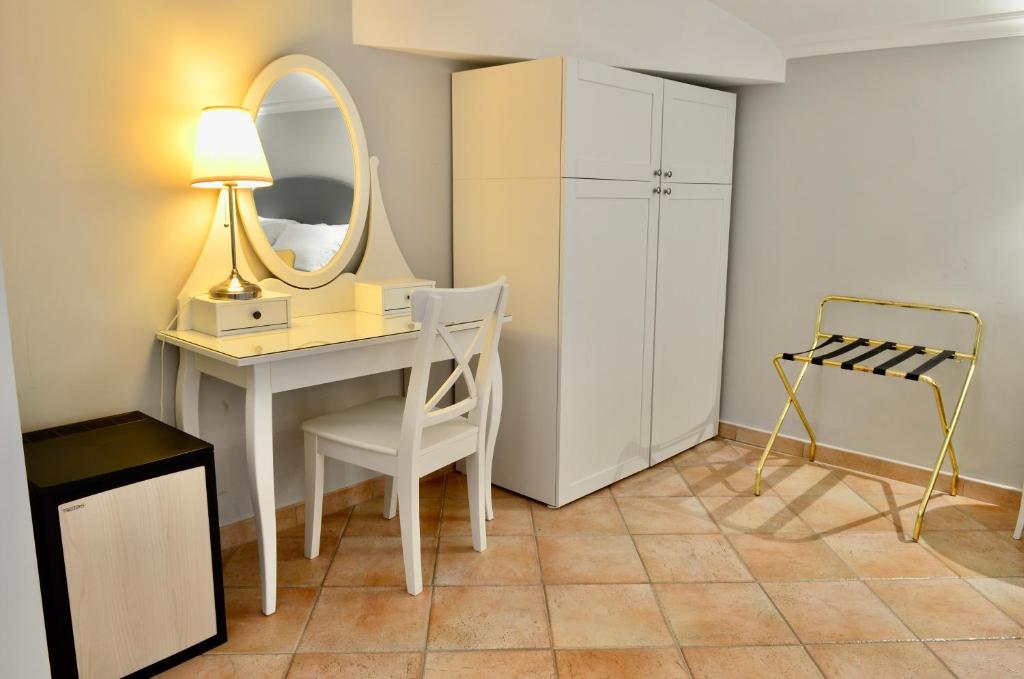Habitación con escritorio, espejo y silla. en Sourire Hotel, en Roma