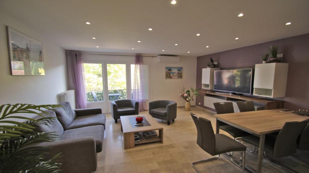 uma sala de estar com um sofá e uma mesa em Les Saisons em Sainte-Maxime