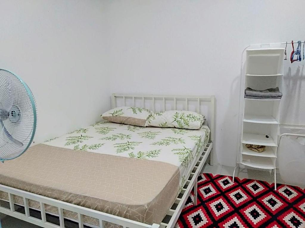 a small bedroom with a bed and a fan at Sri Manik Guest House Tanjung Karang in Tanjung Karang