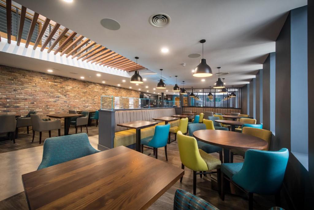 a restaurant with tables and chairs and a brick wall at The Park Hotel in Kilmarnock