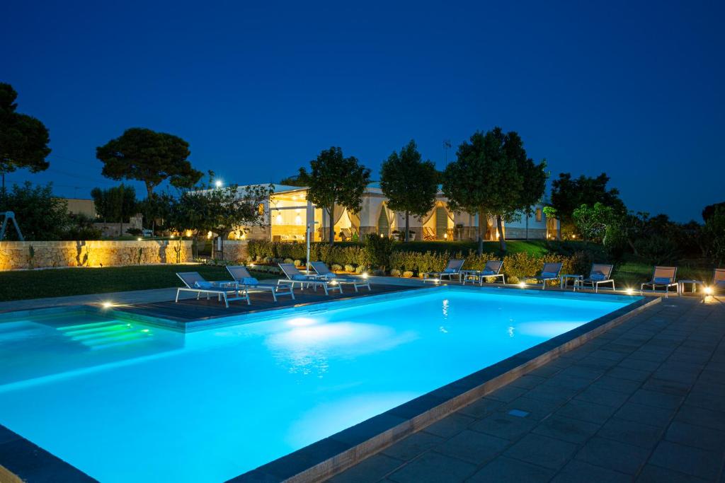 a swimming pool lit up at night at Podere40 Country Hotel in Porto Cesareo