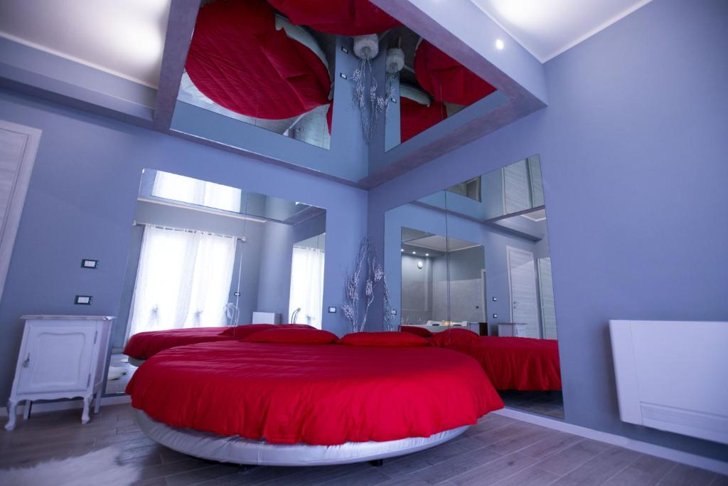 a bedroom with two beds with red pillows at Cupido da Simona in Ostellato