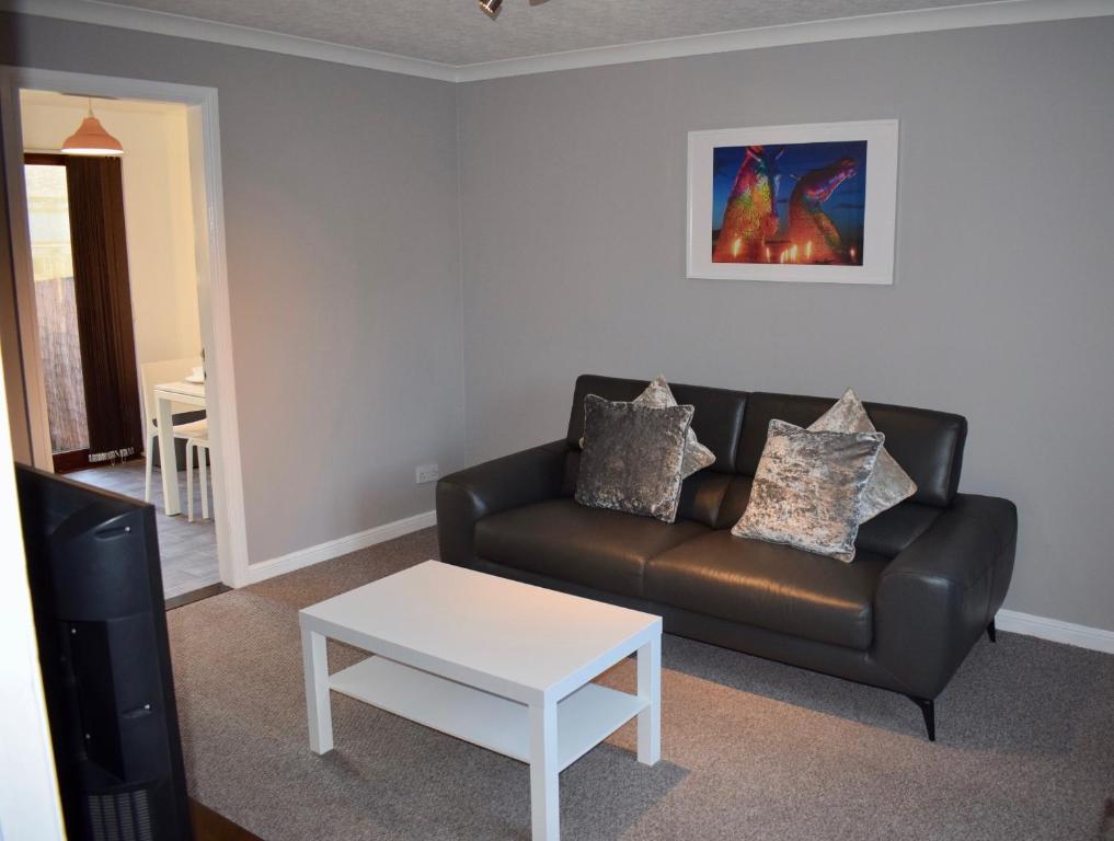 a living room with a couch and a table at Kelpies Serviced Apartments Hamilton- 2 Bedrooms in Falkirk