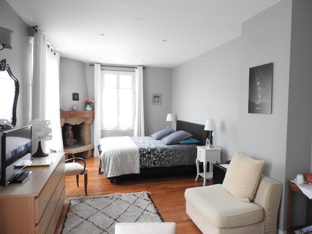 ボワ・ル・ロワにあるChambre d'hôte La Bacotterieのベッドルーム1室(ベッド1台、ソファ、椅子付)