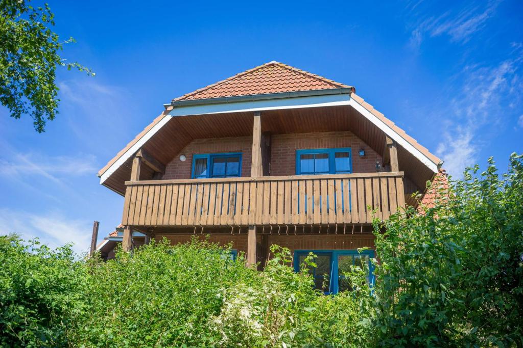 a large wooden house with a gambrel roof at Ferienwohnung-Elke in Lemkenhafen auf Fehmarn