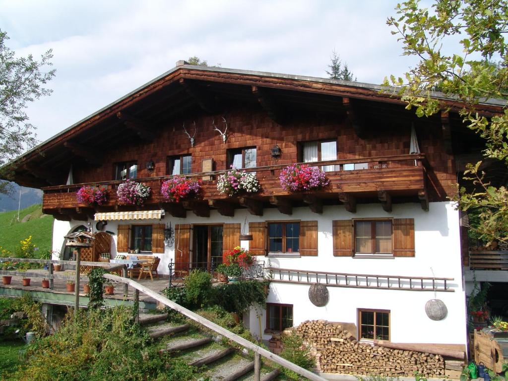 una casa en las montañas con flores en Ferienwohnung Klappacher, en Maria Alm am Steinernen Meer
