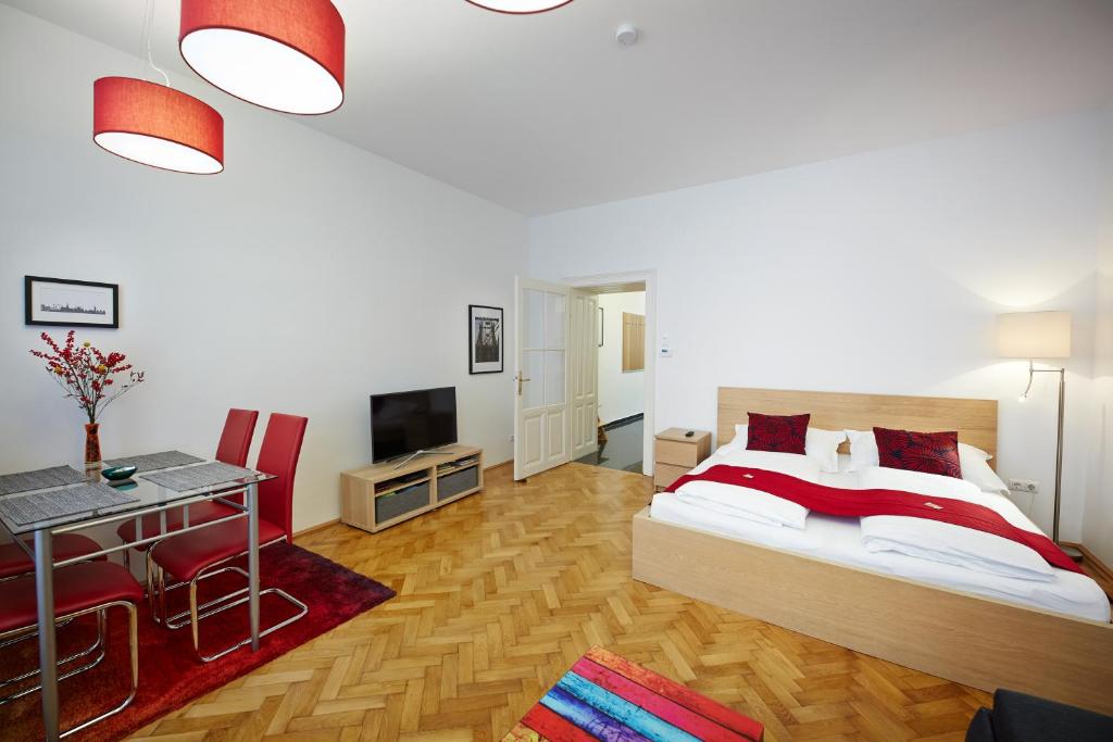 a bedroom with a bed and a table and a television at Stadthalle - FamilyCityApartment in Vienna