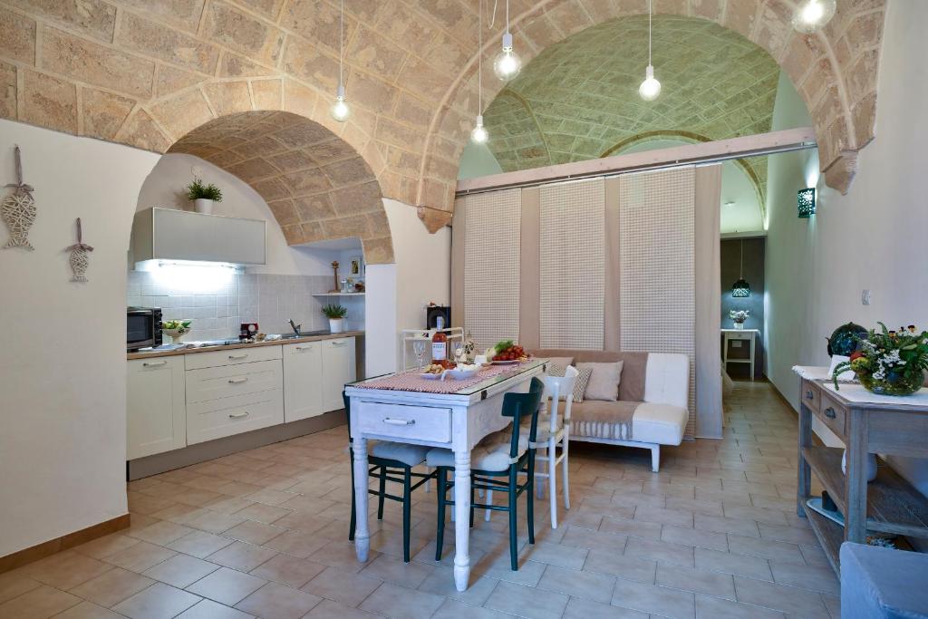 a kitchen and living room with a table and chairs at Dimora Cardinale in Polignano a Mare