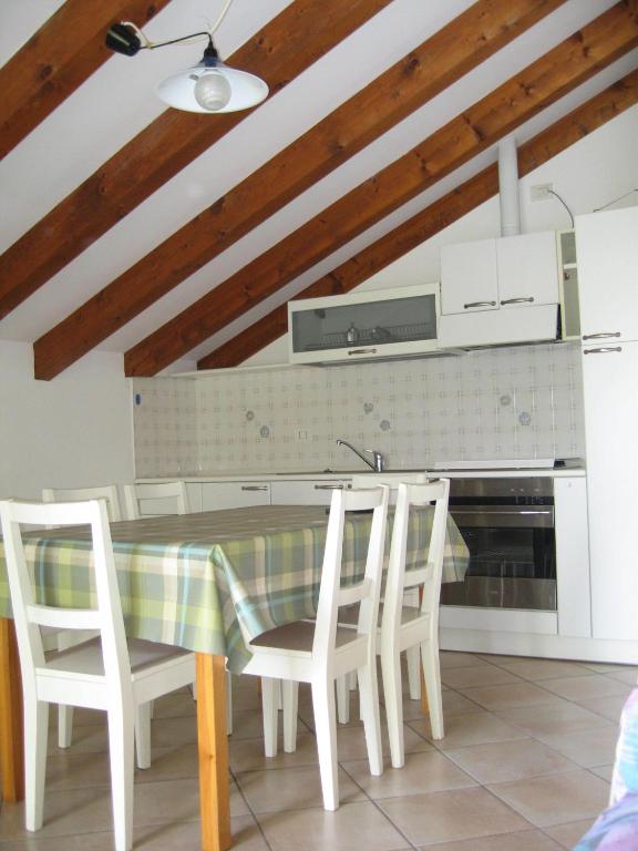 a kitchen with a table with chairs and a stove at Green Village Accommodations in Colico