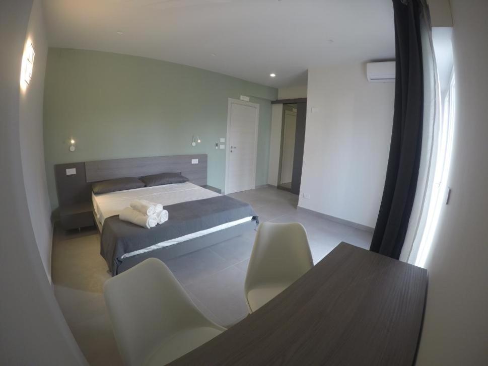 1 dormitorio con 1 cama, mesa y sillas en B&Benny, en Reggio Calabria