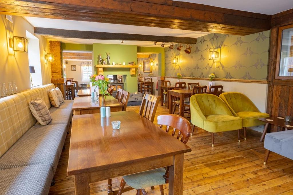 una sala de estar con mesas y sillas y un comedor. en The Dukes Head Inn, en Armathwaite