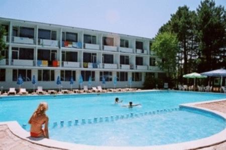 a woman standing in a swimming pool in front of a building at Hotel Horizont in Golden Sands