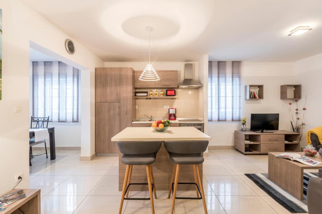 a kitchen and living room with a island with stools at Varoš apartment in Split