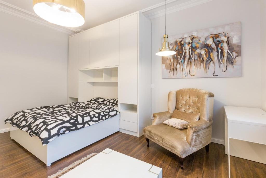 ein Schlafzimmer mit einem Bett und einem Stuhl in der Unterkunft Belgrade Center Apartment Slavija Square II in Belgrad