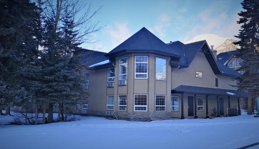 a large house with snow in front of it at Mountain View Inn in Canmore