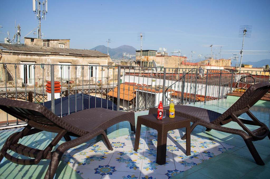 Un patio con dos sillas y una mesa en un balcón. en Bed Boutique Napoli Colors, en Nápoles