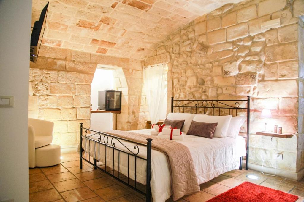 sypialnia z łóżkiem w kamiennej ścianie w obiekcie Suite dei Longobardi w mieście Lecce