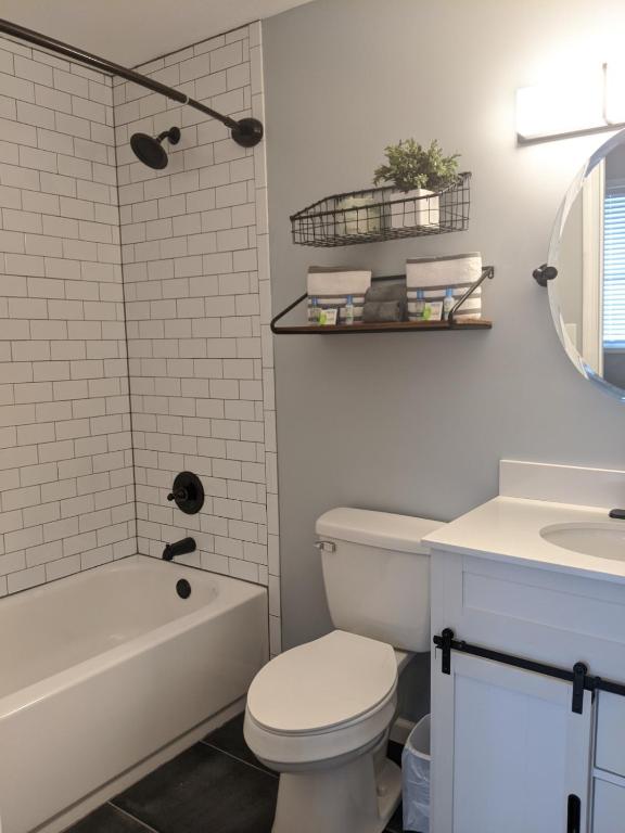 a bathroom with a toilet and a tub and a sink at Heidi Motel - Helen in Helen