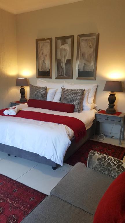 a bedroom with two beds and two lamps and pictures on the wall at Guest House Frame Ace in Bellville