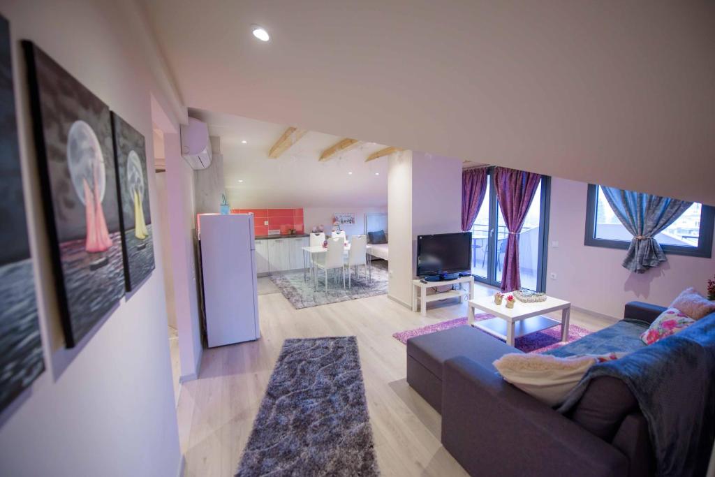 Il comprend un salon avec un canapé bleu et une cuisine. dans l'établissement New Loft Polixeni, à Ioannina
