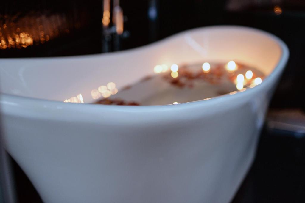 Una taza blanca de café con una vela. en DIAMOND LADY Romantyczny i Luksusowy Apartament, en Szczecin