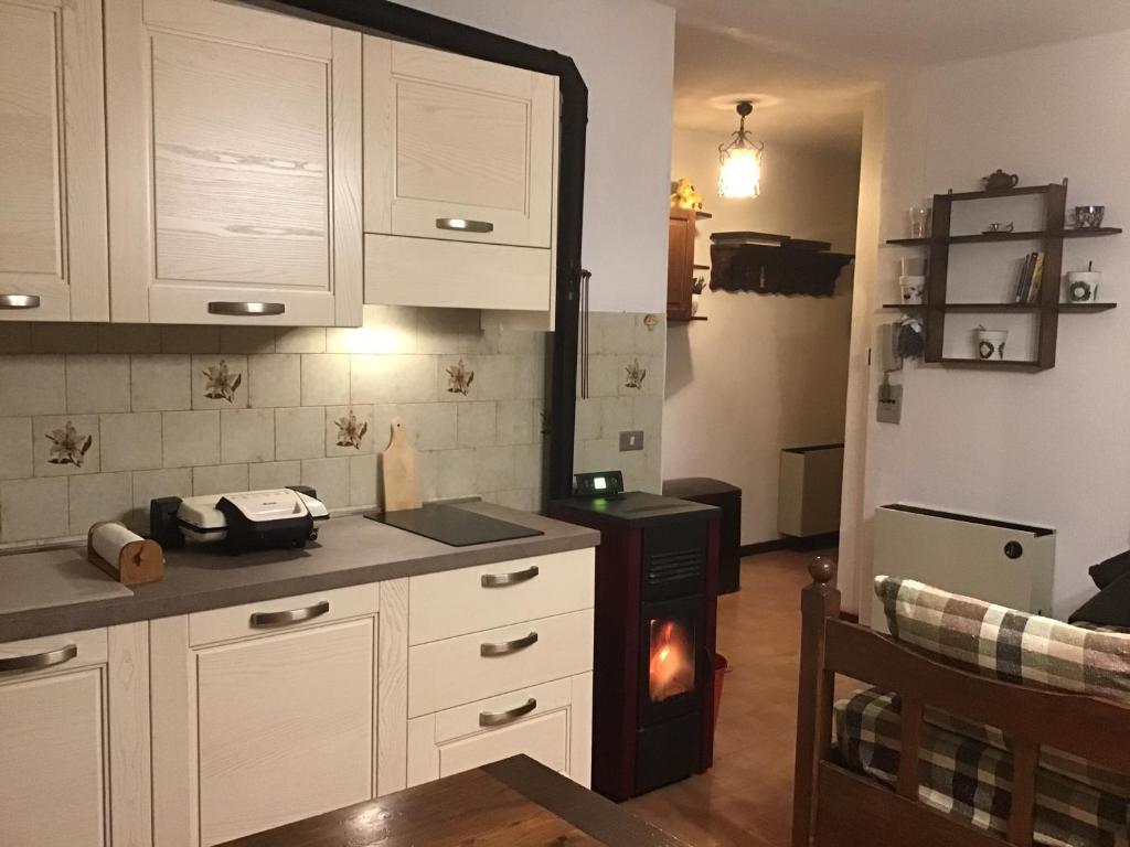 uma cozinha com armários brancos e um fogão em Appartamento arredato con angolo cottura em Argentera