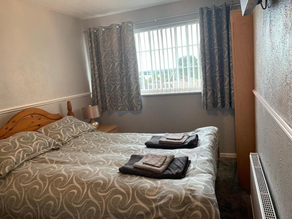 um quarto com uma cama com duas toalhas em Beautiful and Peaceful village location em Bishop's Wood