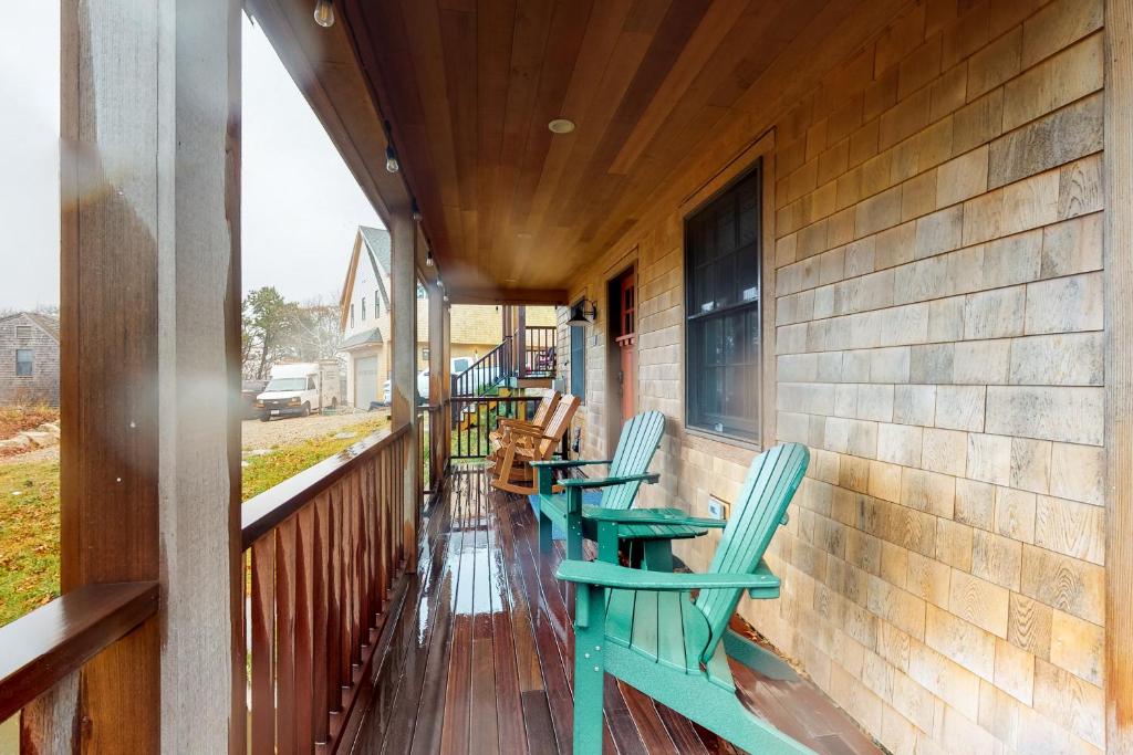 un porche con sillas y mesas en una casa en Summer Sun en Provincetown