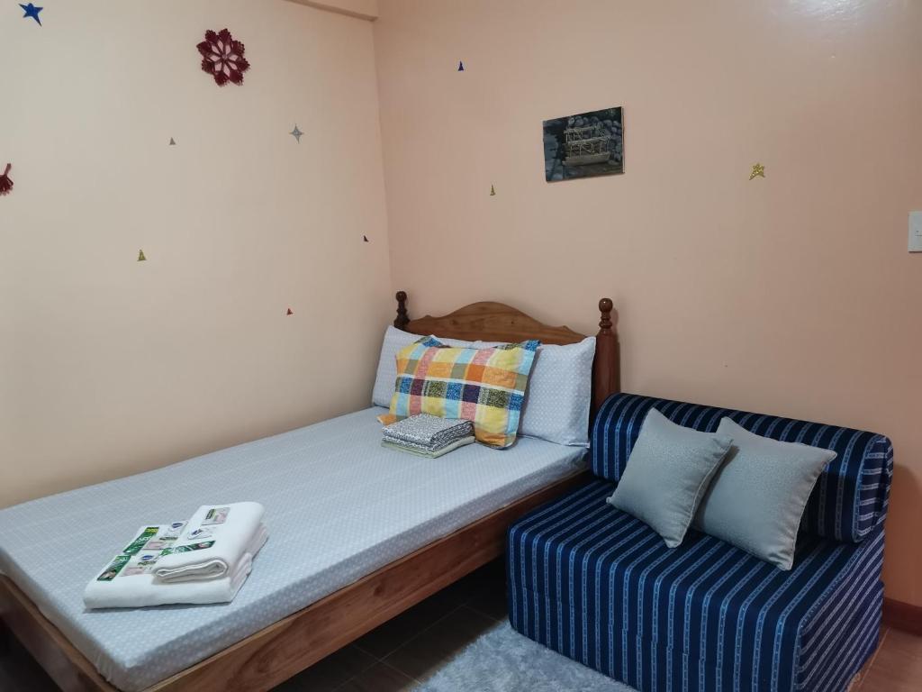 AN Velayo Homestay (ANVEL) في باسكو: سرير وكرسي في غرفه