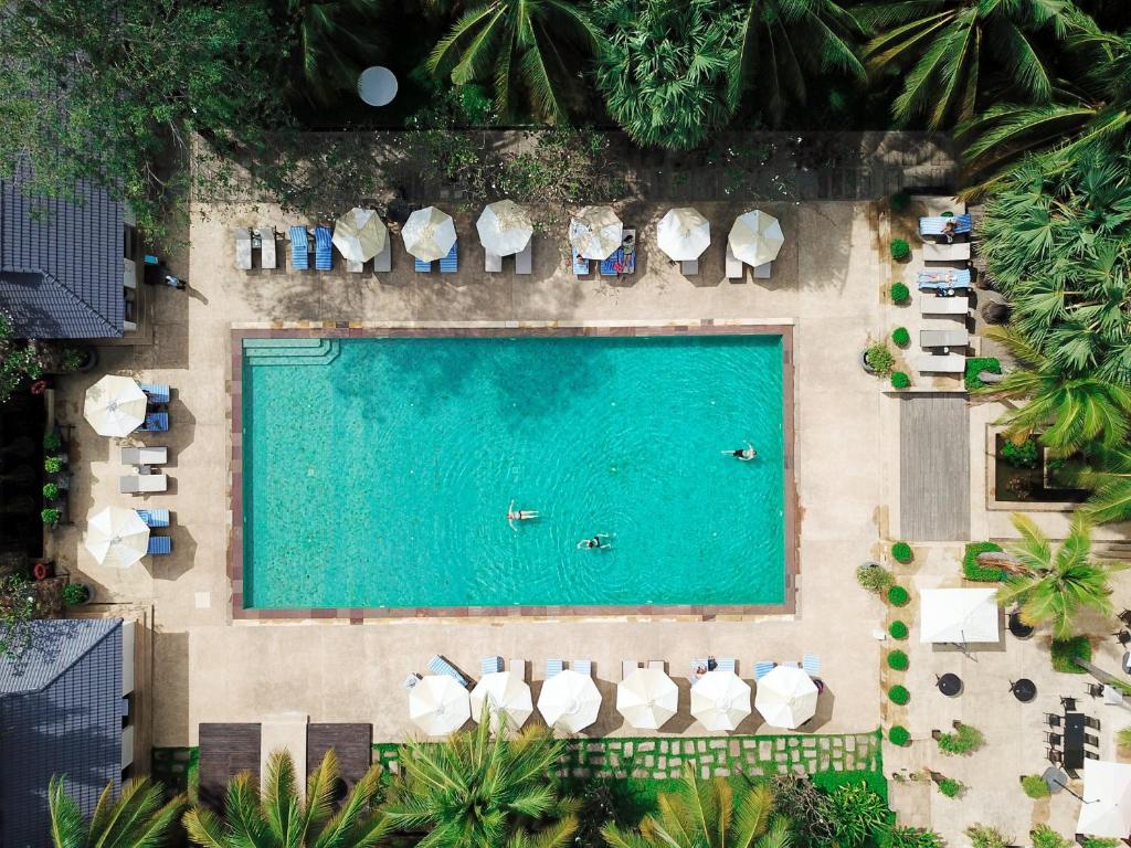 eine Aussicht über einen Pool mit Liegen in der Unterkunft Lotus Blanc Hotel in Siem Reap