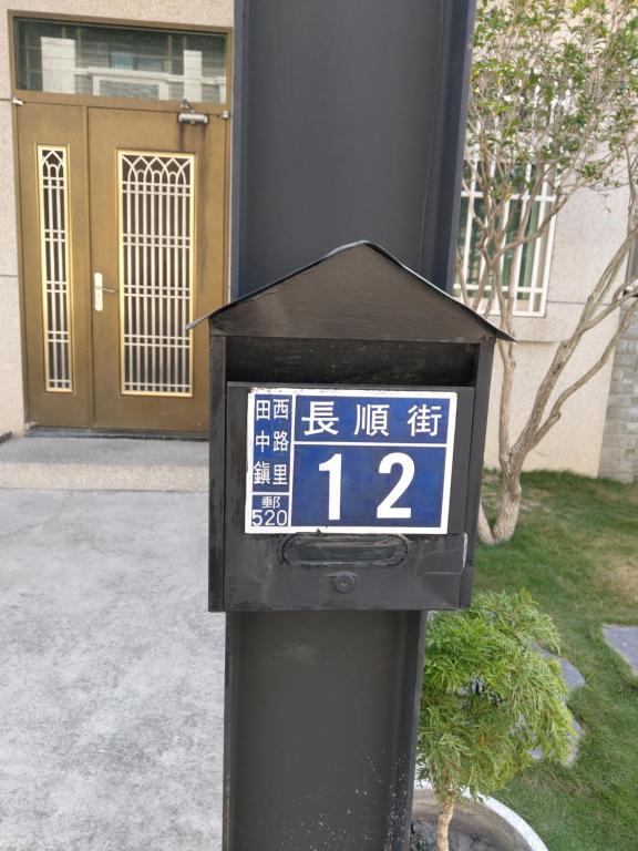 un reloj en un poste frente a un edificio en Li Yuan Homestay en T'ien-chung