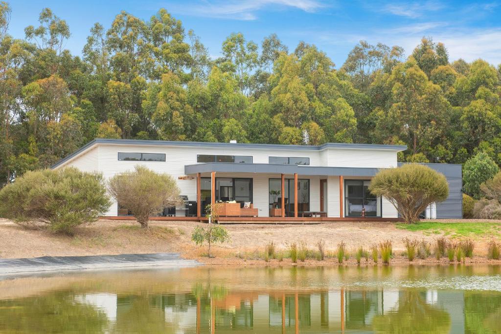 a house with a lake in front of it at Wharfedale in Wilyabrup